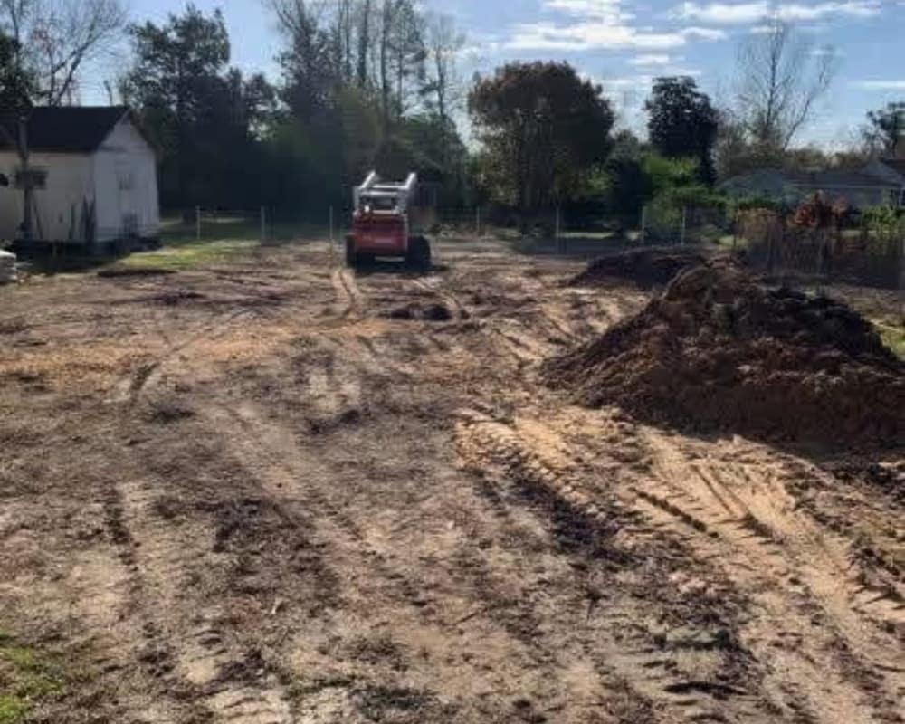 Skid steer clearing a lot and prepping the site